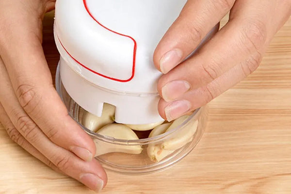 White hand-pulled garlic grinder, ideal for shredding garlic easily in the kitchen.