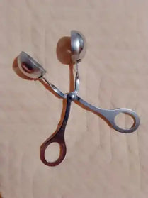 Metal scissors with curved handles casting a shadow.