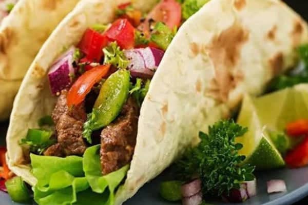 Delicious tacos filled with fresh vegetables, lettuce, and seasoned beef, showcasing the innovative Toaster Taco Shell Maker for perfect taco shells.