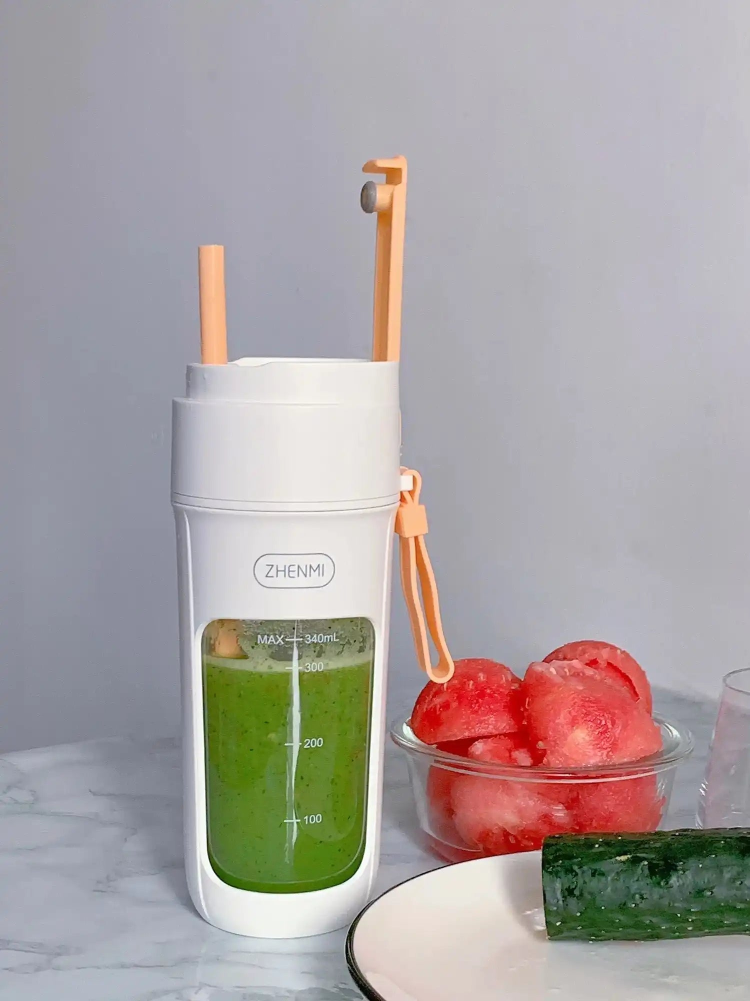 Portable white blender with green smoothie.