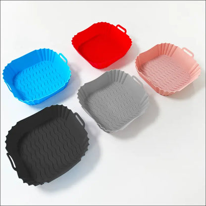 Colorful silicone air fryer trays in various shapes for versatile kitchen use