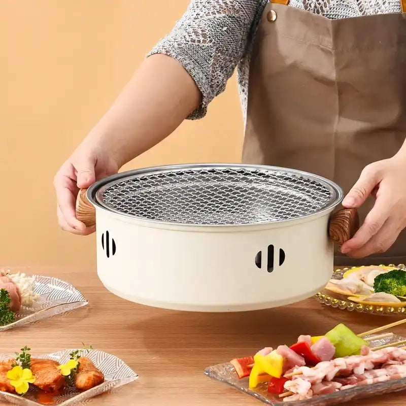 White ceramic yakiniku grill with a mesh grate top and ventilation holes on the sides.